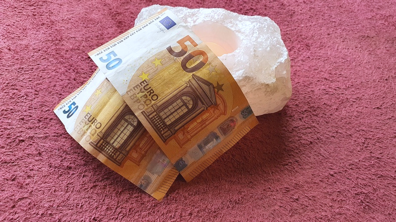 due banconote da 50 euro su tappeto rosso e candela accesa